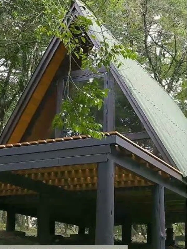 Detalhe de telhado A-frame com estrutura metálica e vigas de madeira